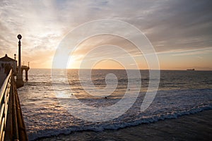 Surfers in the sunset near pier