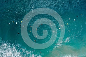 Surfers with surfboards in blue ocean waiting wave. Aerial view