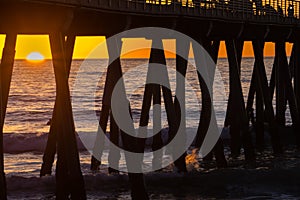 Surfers under the Hermosa Beach Pier photo