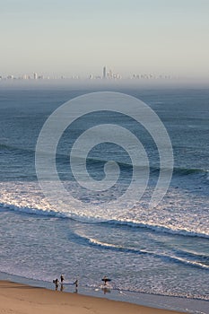 Surfers walking along beach