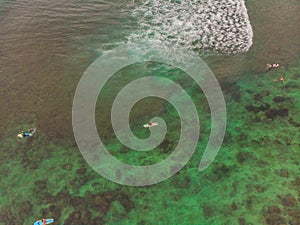 Surfers on the waves in the ocean, top view