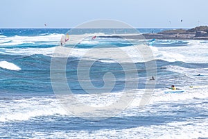 Surfers and windsurfers on the waves of El Medano