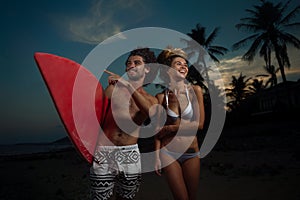 Surfig couple posing on the beach