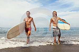 Surfing. Cheerful Young Surfers With Surfboards. Handsome Men Walking On Ocean Beach.