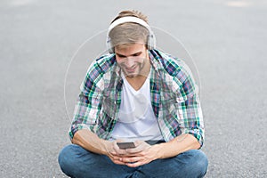 Surfing internet. man checkered shirt. male fashion. student relax use phone. guy chatting outdoor. man sit on ground