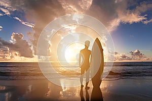 Surfing man standing on a beach photo