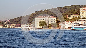 Surfing passenger boats on the bosphorus straits and uskudar shorescape photo