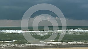 Surfing at stormy sea on dark blue cloudy sky background