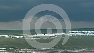 Surfing at stormy sea on dark blue cloudy sky background