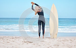 Surfing, stretching and woman surfer on beach standing by surfboard. Blue sky, ocean and girl ready to surf, doing