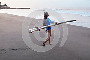 Surfing. Surfer Girl Walking Into Ocean. Young Brunette Carrying Surfboard And Going To Surf.