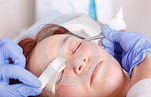 Surgeon applies a bandage to the female patient`s eyelids after