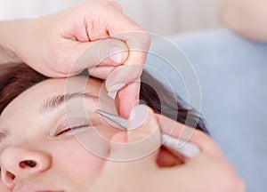 Surgeon applies a bandage to the female patient`s eyelids after