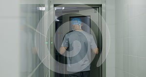 Surgeon comes to operating room and puts on lab coat