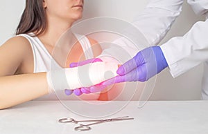 A surgeon doctor examines a patient s palm for a fracture or crack in a bone. Scaphoid fracture, red photo