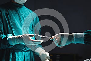 Surgeon doctor holding surgical scissors and passing surgical equipment to each other in the operating room at hospital.