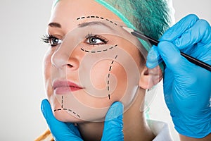 Surgeon Drawing Perforation Lines On Woman`s Face photo