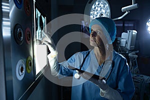 Surgeon examining x-ray on light box in operating room of hospital