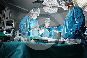 Surgeon group, people and operating room at hospital in scrubs, ppe and help for emergency healthcare procedure. Doctors