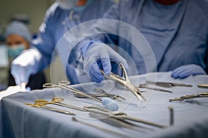 Surgeon hand taking surgical tools from tray