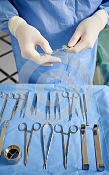 Surgeon hands holding scalpel in operating room.