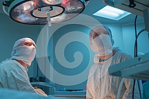 The surgeon and his assistant in the operating room look at the monitor, performing a laparoscopic operation