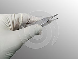 Surgeon Holding Adson Brown Forceps With Gloved Hand. Selective Focus