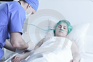 Surgeon injecting ill woman photo