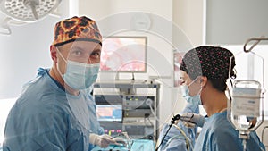 Surgeon looking at camera with colleagues. Team surgeon at work on operating in hospital. A team of surgeons carefully
