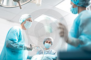 Surgeon looking at nurse while using laparoscope during surgery photo