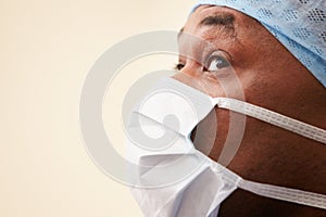 Surgeon In Operating Theatre Wearing Scrubs And Mask