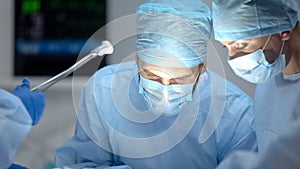 Surgeon performing operation, assistant hand holding medical tools, medicare