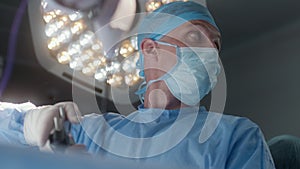 Surgeon performing operation using tools