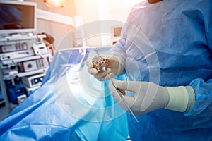 Surgeon performs endoscopic microdiscectomy of herniated intervertebral disc.