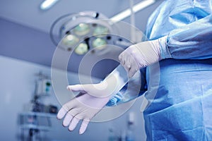 Surgeon putting on rubber gloves before a difficult operation
