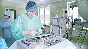 Surgeon's assistant prepares tools for surgery