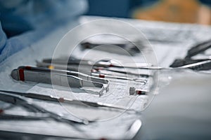 The surgeon`s hands are holding an operating tool in the operating room. Close-up, beautiful light, modern medicine