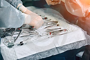 The surgeon`s hands are holding an operating tool in the operating room. Close-up, beautiful light, modern medicine