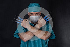 Surgeon in scrubs with syringes arms crossed