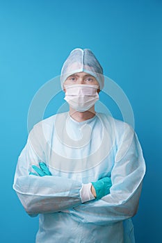 Surgeon in sterile blue uniform, medical gloves and mask