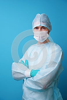 Surgeon in sterile blue uniform, medical gloves and mask