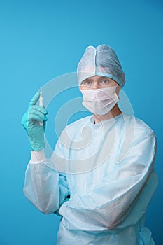 Surgeon in sterile blue uniform, medical gloves and mask