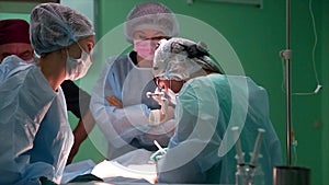 The surgeon and surgical team perform cosmetic surgery on the Breasts in a hospital operating room. The breast