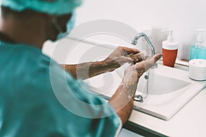 Surgeon washing hands before operating patient in hospital - Medical worker getting ready for fighting against corona virus