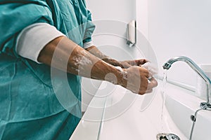 Surgeon washing hands before operating patient in hospital - Medical worker getting ready for fighting against corona virus