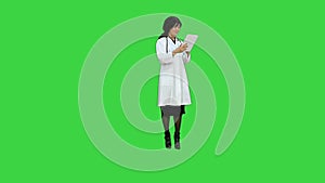 Surgeon woman doctor smile using tablet pc and talking to a camera on a Green Screen, Chroma Key