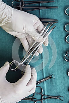 Surgeon working in operating room, hands with gloves holding scissors, conceptual image