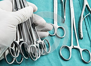 Surgeon working in operating room, hands with gloves holding scissors sutures