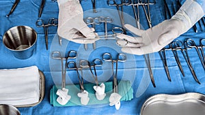 Surgeon working in operating room, hands with gloves holding scissors sutures