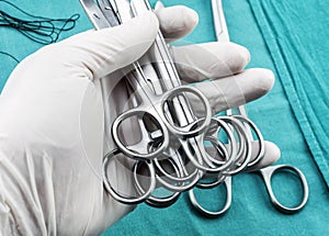 Surgeon working in operating room, hands with gloves holding scissors sutures, conceptual image